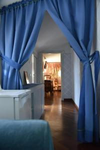 a blue curtain in a living room with a table at Maison Brinati Bed and Breakfast in Monsummano Terme