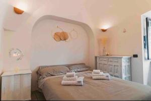 ロコロトンドにあるTrulli Nonna Graziellaのベッドルーム1室(大型ベッド1台、タオル付)