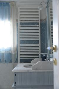 La salle de bains est pourvue d'un lavabo et d'un miroir. dans l'établissement Maison Brinati Bed and Breakfast, à Monsummano