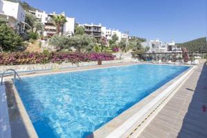 a pool at a resort with buildings in the background at Impressive House near Paradise Bay in Bodrum in Golturkbuku