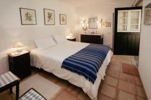 um quarto com uma cama com um cobertor listrado azul e branco em Cottage São Veríssimo 