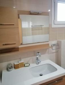 a bathroom with a white sink and a mirror at Breathtaking sea view in Kavala