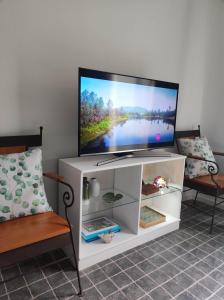 a flat screen tv on a white entertainment center at Quinta dos Chorões in São Vicente Ferreira
