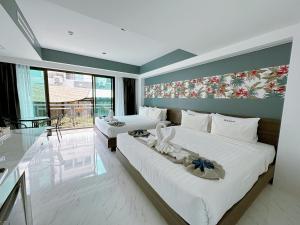 1 dormitorio con 2 camas y ventana grande en Machorat Aonang Resort at Aonang Beach Krabi, en Ao Nang Beach