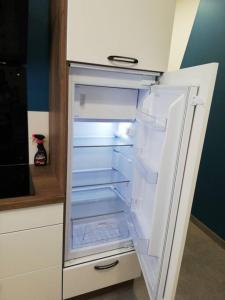 um frigorífico vazio com a porta aberta numa cozinha em Bel appartement cœur de Grenoble tout équipé em Grenoble