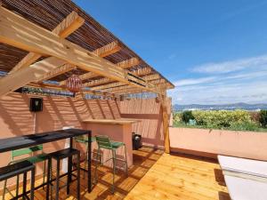 patio con tavolo in legno e pergolato di Superbe appartement avec Rooftop privé a Saint-Tropez