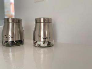 two metal jars sitting on top of a counter at Amarielia's Studios in Tinos