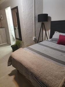 um quarto com uma cama grande e uma almofada vermelha em Comfort place 2 em Pretoria