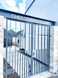 a gate with a sign that reads chest tension news at 2 Bedroom Modern House in Cambridge city centre in Chesterton
