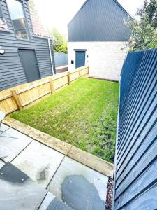 a backyard with a wooden fence and a yard at 2 Bedroom Modern House in Cambridge city centre in Chesterton