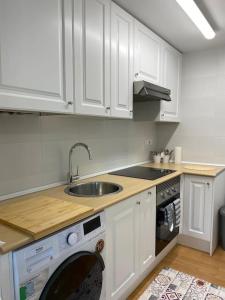 索拉雷斯的住宿－Estudio en Solares, Cantabria，厨房配有白色橱柜、水槽和洗碗机。