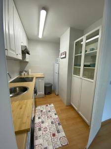 uma pequena cozinha com armários brancos e um lavatório em Estudio en Solares, Cantabria em Solares