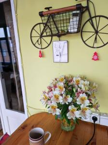 un vase de fleurs sur une table avec un vélo sur le mur dans l'établissement Hostel ERA, à Tbilissi