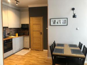 kuchnia ze stołem i krzesłami oraz drzwiami w obiekcie Apartament Zamkowy Stare Miasto w mieście Lublin