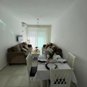 un soggiorno con tavolo e sedie bianchi di Low Cost Banesa Kosovare a Shëngjin