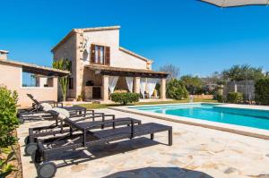 a villa with a swimming pool and a house at Finca Cari in Can Picafort