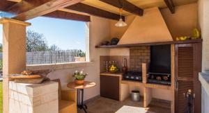 a kitchen with a stove top oven next to a window at Finca Cari in Can Picafort