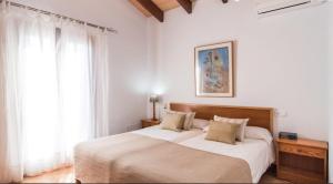 a bedroom with a large bed with white sheets at Finca Cari in Can Picafort +35 photos