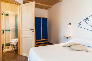 1 dormitorio con cama blanca y ventana azul en The Old Farm Asfodeli - Adults Only, en Sanalvò