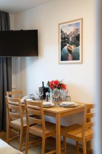 a dining room table with chairs and a painting on the wall at Ferienwohnung Wendelstein in Kiefersfelden