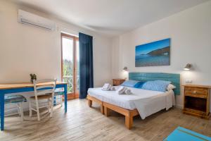 a bedroom with a bed and a desk and a table at Dery Alghero Holiday Rooms in Alghero