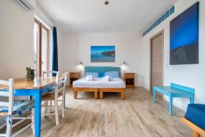a bedroom with a bed and a table and a dining room at Dery Alghero Holiday Rooms in Alghero