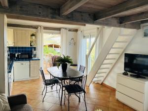 a kitchen and dining room with a table and chairs at Hameau de pietra longa Salvini PORTO-VECCHIO in Sotta