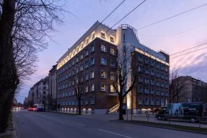 duży budynek przy ulicy miejskiej o zmierzchu w obiekcie Balcia Residence w Rydze
