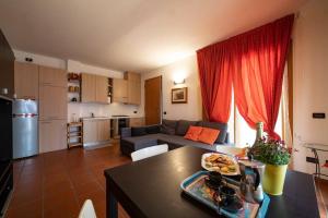 uma cozinha e sala de estar com uma mesa e um sofá em In suite lake 3 em Pilzone