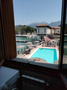 uma vista para uma piscina a partir de uma janela em In suite lake 3 em Pilzone