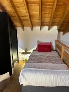 una camera da letto con un cuscino rosso di B&C Furnas House a Furnas