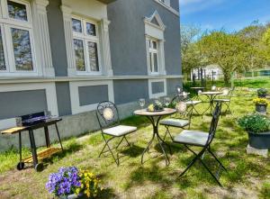 un grupo de mesas y sillas frente a una casa en Altes Fischerhaus am Grimnitzsee en Joachimsthal
