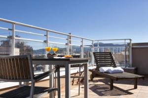einen Balkon mit einem Tisch und 2 Gläsern Wein in der Unterkunft Zenit Murcia in Murcia