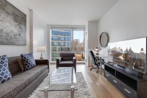 ein Wohnzimmer mit einem Sofa und einem TV in der Unterkunft Global Luxury Suites at Via 57 in New York