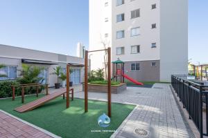 un parque infantil en un edificio con zona de juegos en Apartamentos completos a 15min BETO CARREIRO com WI-FI CHURRASQUEIRA em CONDOMÍNIO com PISCINA portaria 24h Ideal para família en Piçarras