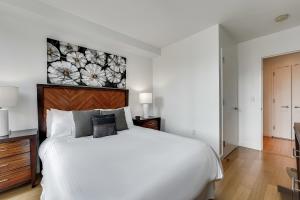 sypialnia z białym łóżkiem z obrazem kwiatowym na ścianie w obiekcie Global Luxury Suites at Via 57 w Nowym Jorku