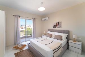 a bedroom with a large bed and a large window at Emelia Cozy Apartment in Rhodes Town