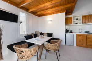 iL Fagiolo Suites في Vourvoúlos: مطبخ وغرفة طعام مع طاولة وكراسي
