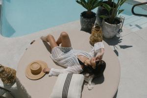 a woman laying on a table next to a pool at Yara Hotel - Adults Only in Palm Springs
