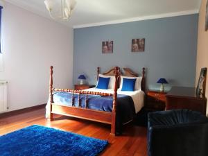 a bedroom with a bed and a blue rug at Casa Travessa da Quinta in Mondim de Basto