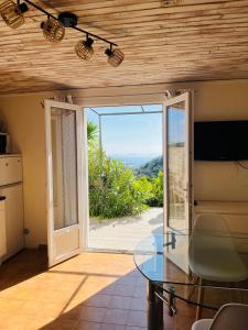 ein Esszimmer mit einem Glastisch und einer Glasschiebetür in der Unterkunft Hameau de pietra longa Salvini PORTO-VECCHIO in Sotta