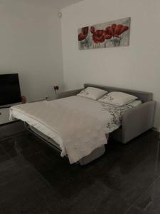 1 dormitorio con 1 cama y una pintura en la pared en Moderno bilocale vista lago Maggiore, en Gordola
