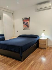 una camera con letto blu e comodino di Piso Castelló en Barrio de Salamanca a Madrid