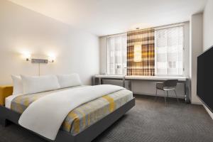 una camera da letto con un letto, una scrivania e una finestra di The Delphi Downtown LA a Los Angeles