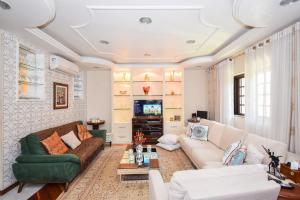 a living room with a couch and a tv at Pousada Dona Clô in Rio de Janeiro