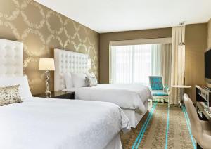 a hotel room with two beds and a window at The Nines, a Luxury Collection Hotel, Portland in Portland