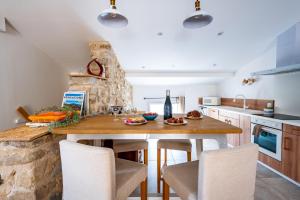 a kitchen with a wooden table and chairs at Le CESAR de luxe in Saint-Romain-en-Viennois