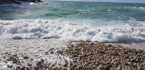 a group of waves crashing on a rocky beach at Apartmani Val in Pula