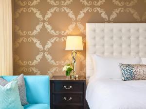 a bedroom with a white bed and a blue chair at The Nines, a Luxury Collection Hotel, Portland in Portland