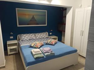 ein blaues Schlafzimmer mit einem Bett mit Handtüchern darauf in der Unterkunft Il paradiso nascosto in Catania